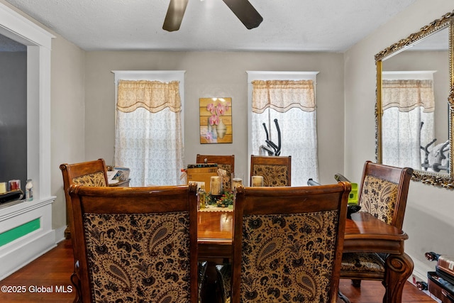 dining area with a textured ceiling, a ceiling fan, and wood finished floors