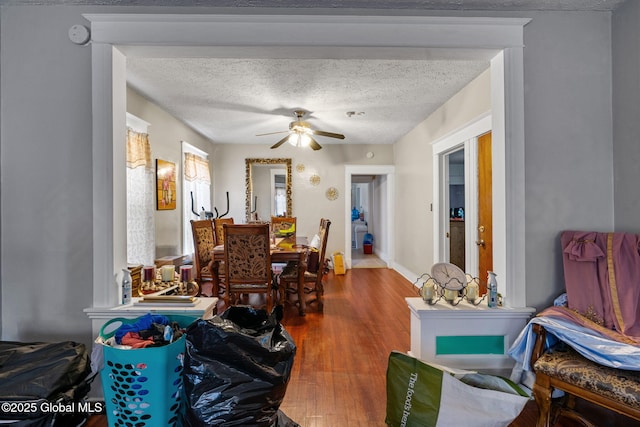 dining room featuring ceiling fan, a textured ceiling, and wood finished floors