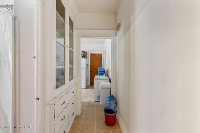 hall with baseboards and light tile patterned floors