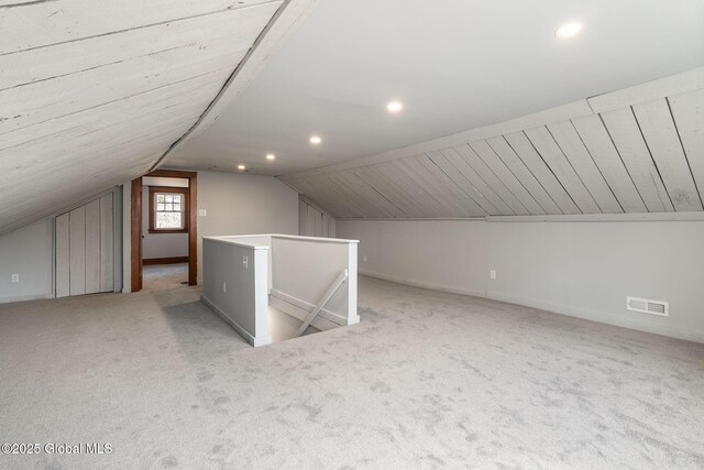 additional living space featuring carpet, visible vents, baseboards, recessed lighting, and vaulted ceiling