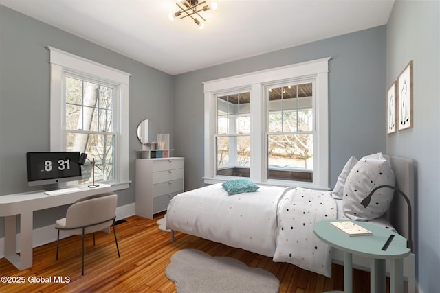 bedroom featuring multiple windows and wood finished floors