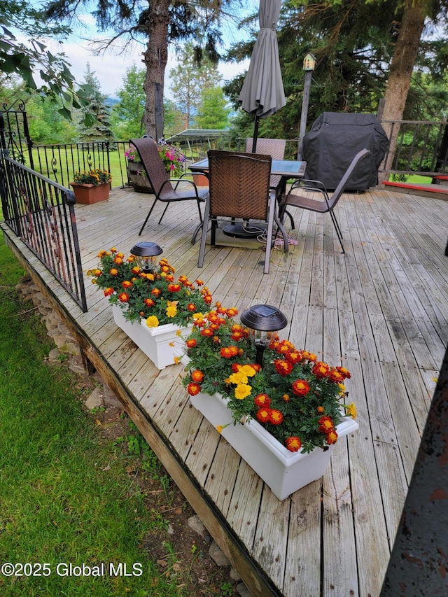 deck featuring outdoor dining space and area for grilling