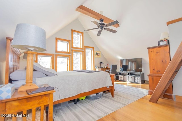 bedroom with high vaulted ceiling and wood finished floors