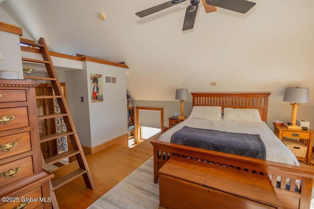 bedroom featuring lofted ceiling, wood finished floors, visible vents, and a ceiling fan