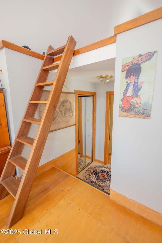 stairs with wood finished floors and baseboards