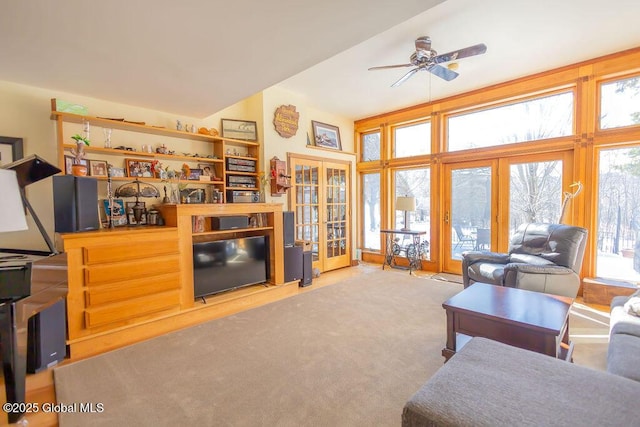 living room with french doors, a ceiling fan, light colored carpet, and a healthy amount of sunlight