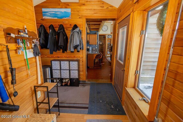 mudroom featuring vaulted ceiling, wood finished floors, and wooden walls