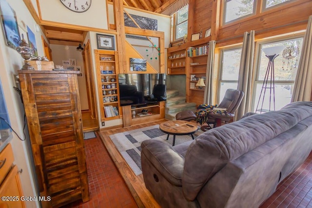 living area with a towering ceiling and wood finished floors