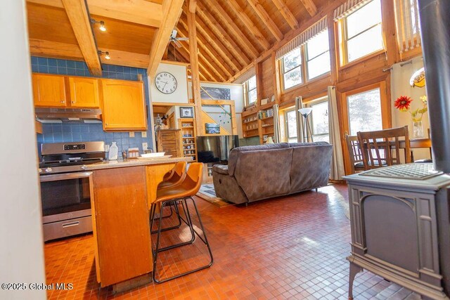 kitchen featuring stainless steel range oven, beam ceiling, wood ceiling, and under cabinet range hood