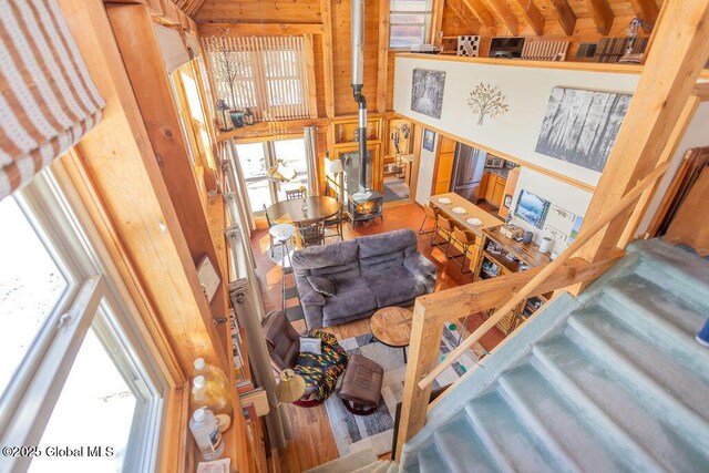 interior space with wooden walls, a high ceiling, and wood finished floors