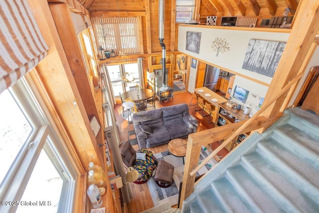 interior space with wooden walls, a high ceiling, and wood finished floors