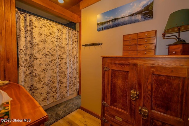 bathroom with a shower with shower curtain and wood finished floors