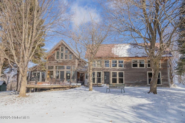 snow covered house with a sunroom