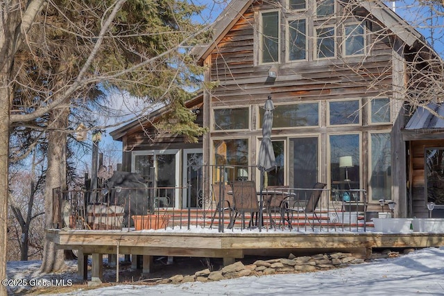 rear view of house with a deck and a sunroom