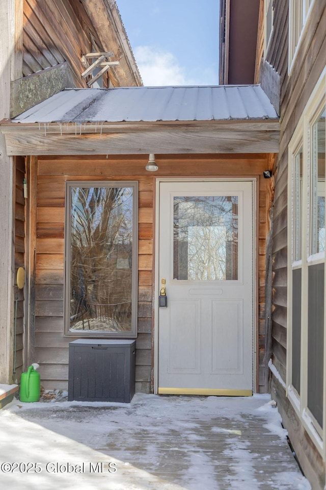 doorway to property featuring metal roof