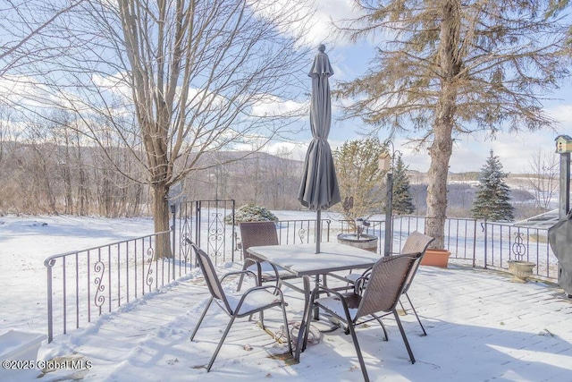 snow covered deck with outdoor dining area