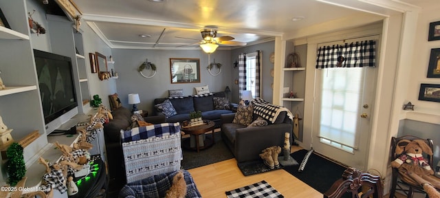 living area with a ceiling fan, crown molding, and wood finished floors