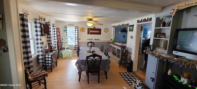 dining area with light wood-style flooring and a ceiling fan