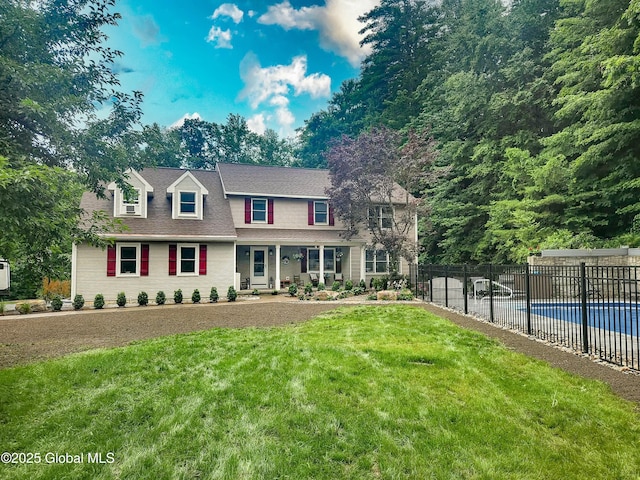 view of front of home with a front yard, fence, and a fenced in pool