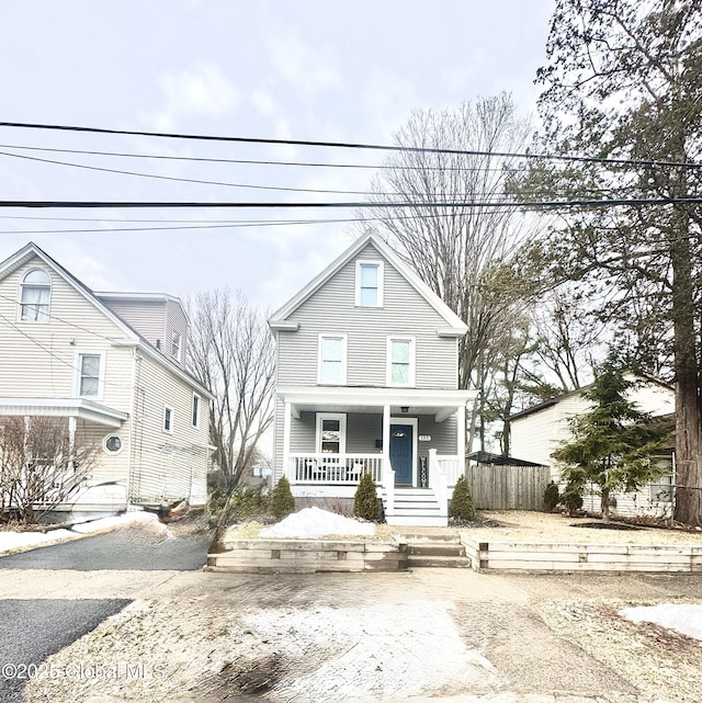 traditional style home featuring a porch and fence