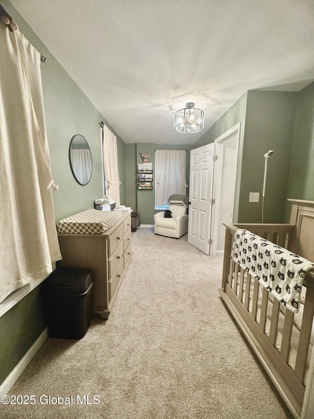 interior space featuring an inviting chandelier, carpet flooring, and baseboards