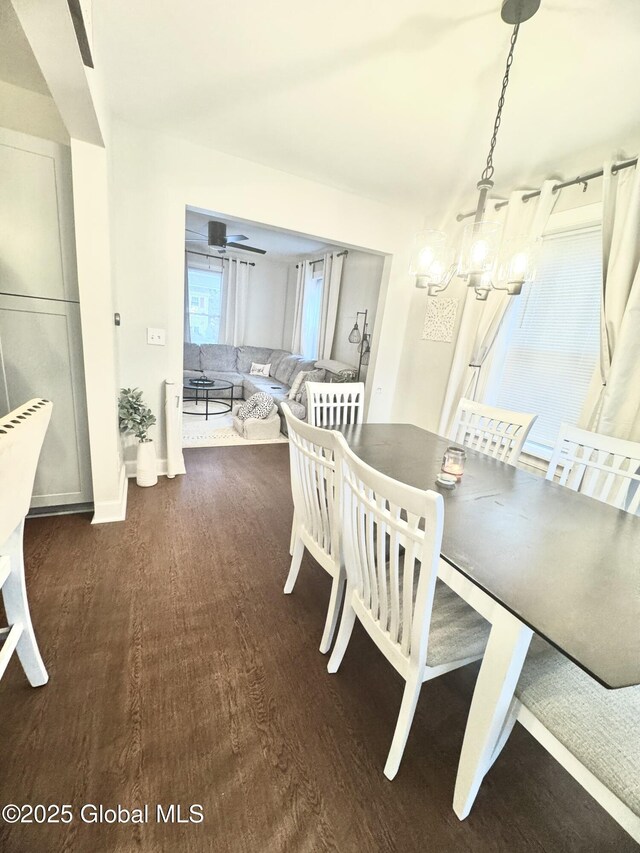 dining space with a notable chandelier, wood finished floors, and baseboards