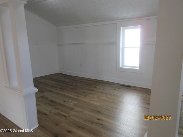 additional living space featuring ornate columns, visible vents, wood finished floors, and wainscoting