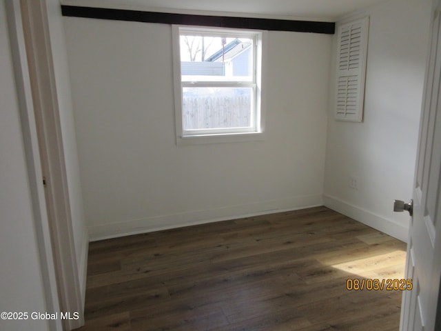 unfurnished room with baseboards and wood finished floors