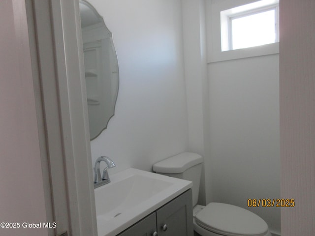 half bath featuring toilet and vanity