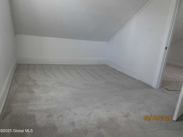 additional living space featuring lofted ceiling and carpet flooring