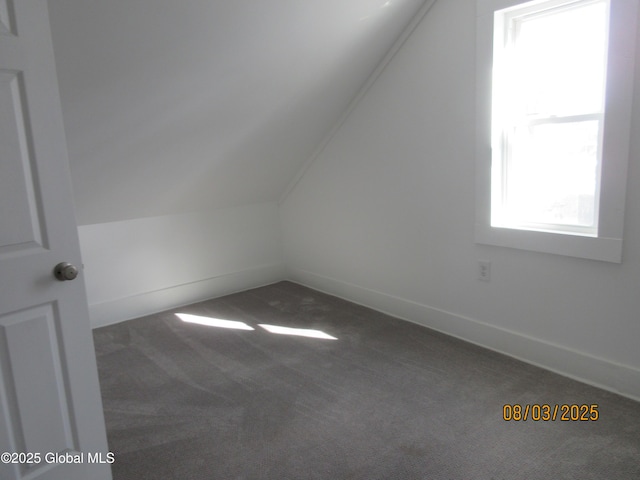 bonus room featuring lofted ceiling, carpet flooring, and baseboards