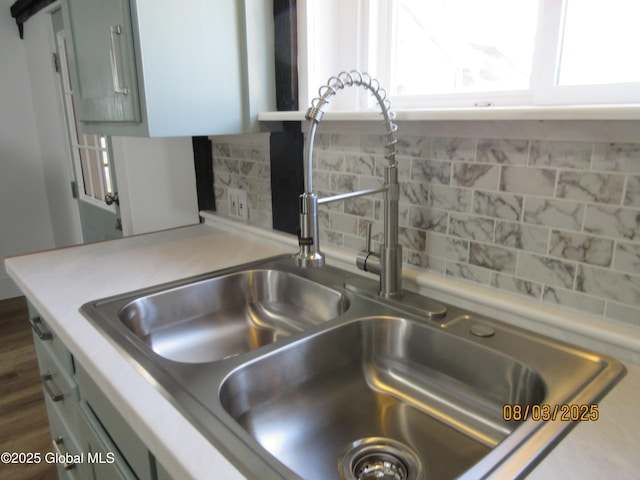 details with backsplash, light countertops, and a sink