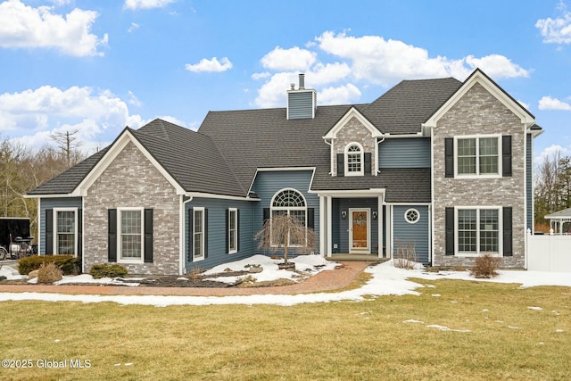 view of front of house with a chimney, a front lawn, and fence