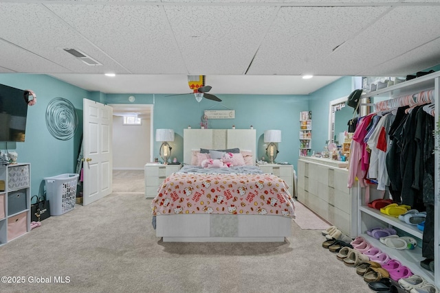 carpeted bedroom featuring visible vents and a drop ceiling