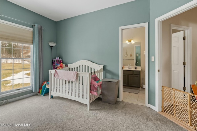 bedroom with ensuite bath, a nursery area, carpet, and a sink