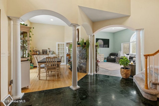 entryway featuring stairway, a towering ceiling, recessed lighting, and ornate columns