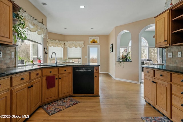 kitchen featuring a sink, open shelves, light wood-style floors, and black dishwasher