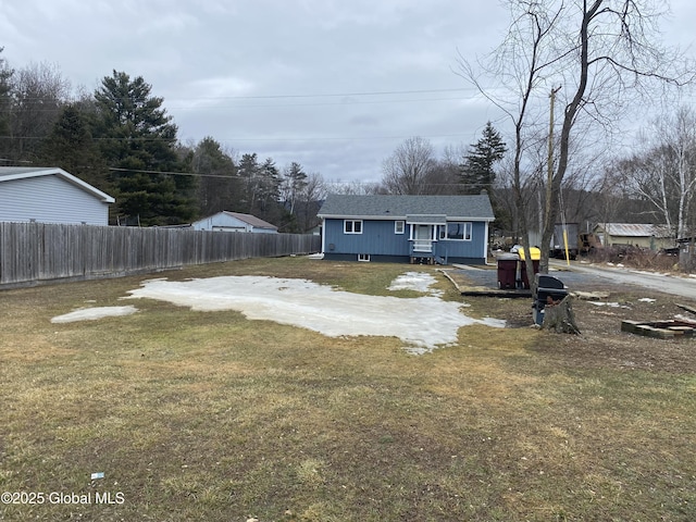 view of front of property featuring a front yard, fence, and driveway