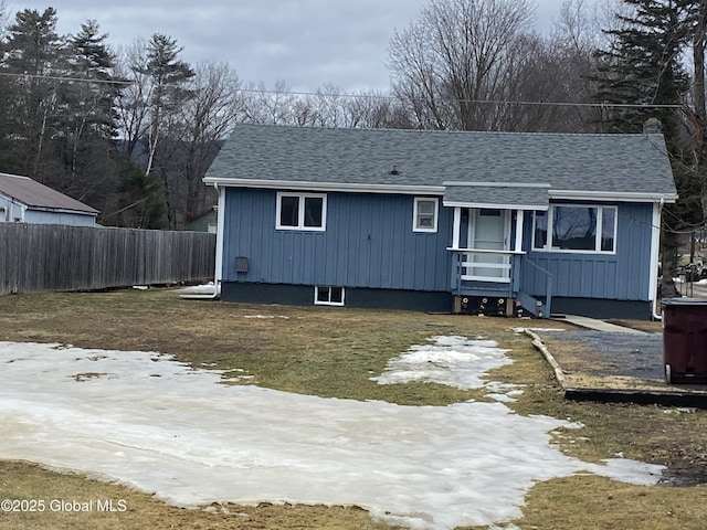 view of front of property featuring a shingled roof and fence