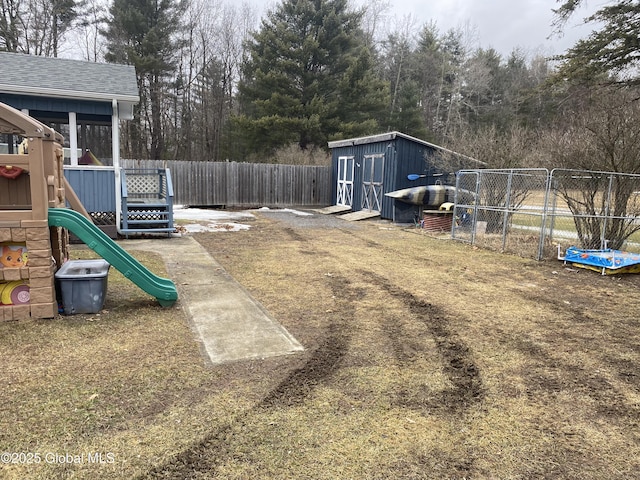 view of jungle gym with an outbuilding, a fenced backyard, and a storage unit