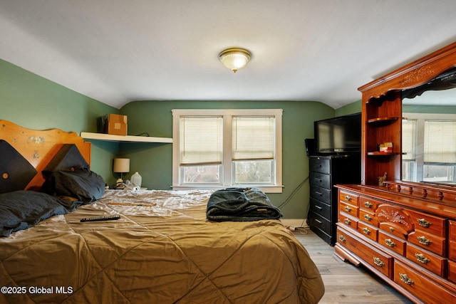 bedroom featuring vaulted ceiling and light wood-type flooring