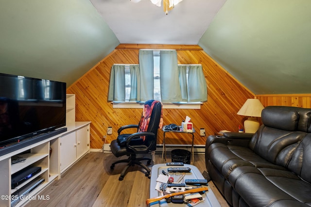 office with a ceiling fan, a baseboard radiator, wood finished floors, vaulted ceiling, and wood walls