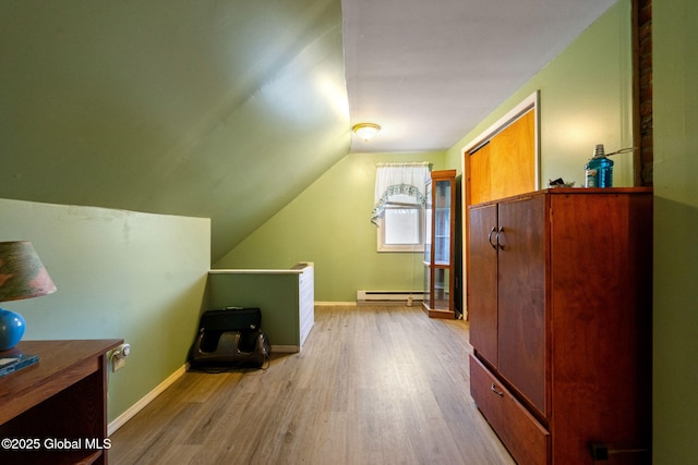 bonus room featuring a baseboard heating unit, vaulted ceiling, wood finished floors, and baseboards