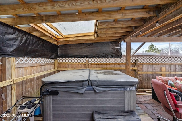 deck with a hot tub and fence