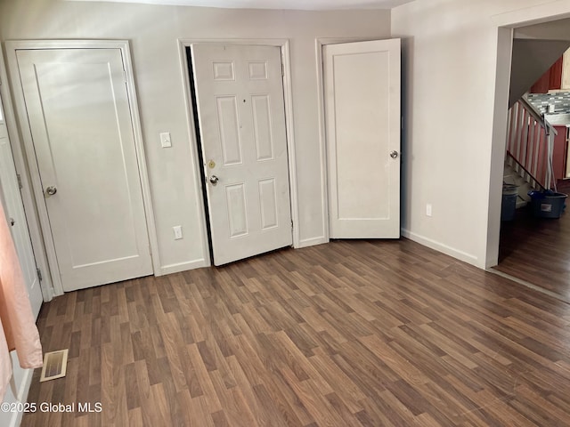 unfurnished bedroom featuring visible vents, baseboards, and wood finished floors