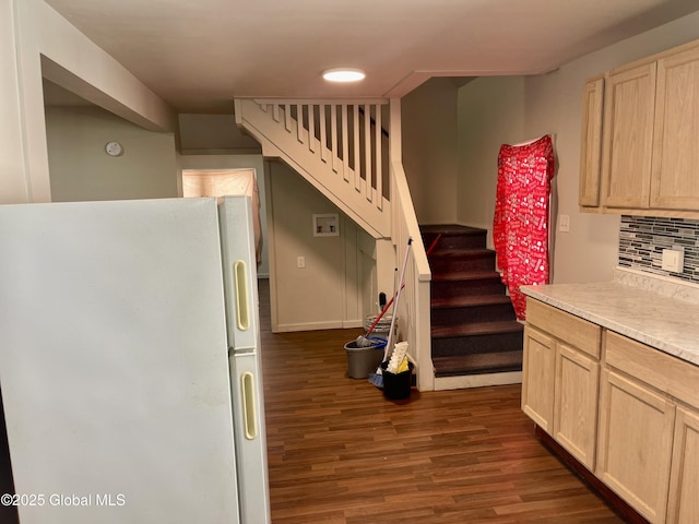 kitchen with light brown cabinets, light countertops, backsplash, freestanding refrigerator, and dark wood finished floors