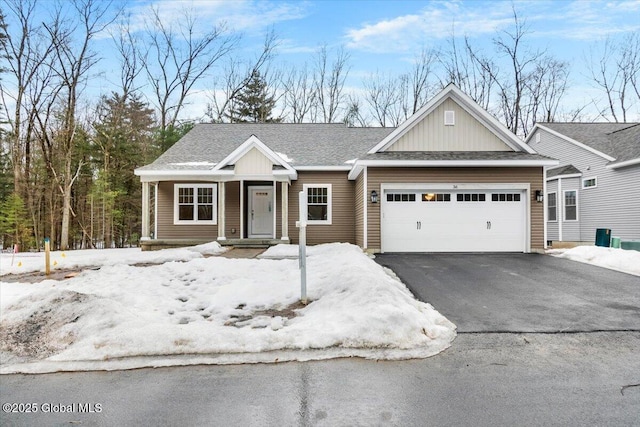 view of front facade with driveway, an attached garage, and a shingled roof