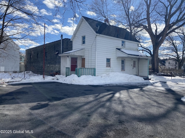 snow covered property with a chimney