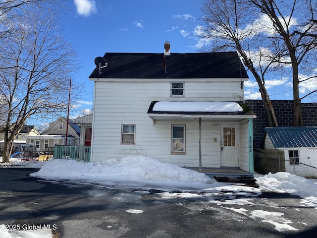 snow covered house with fence