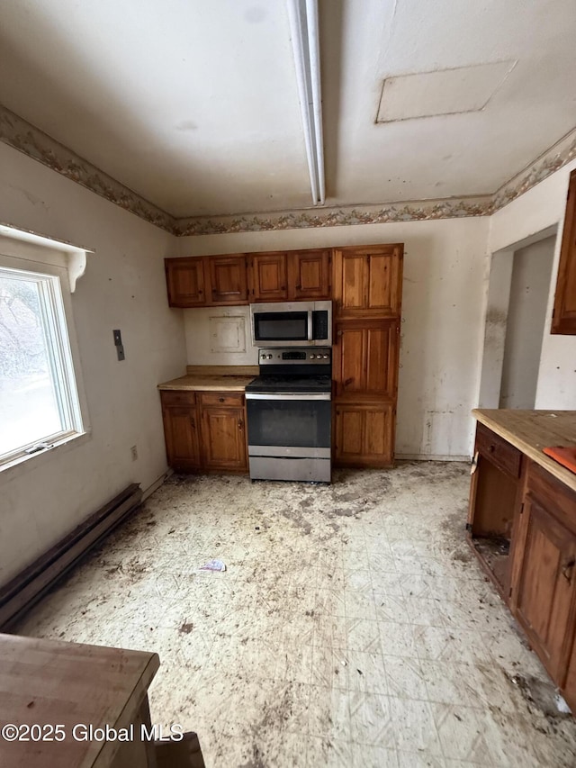 kitchen with brown cabinets, light floors, stainless steel appliances, a baseboard radiator, and light countertops